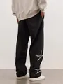 Vue détaillée d'un pantalon noir streetwear avec broderie étoile blanche sur la jambe - Noir