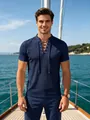 Detail view of men's navy blue lace-up polo shirt with waffle texture on a yacht. - Navy Blue