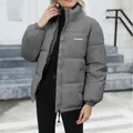 Detail view of a grey stand-collar puffer jacket for women in a winter outdoor setting - S / Tops / Gray
