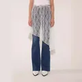 Dettaglio di una gonna asimmetrica in pizzo bianco sovrapposta a jeans in denim blu - Taglia unica / Stile Irregolare (Pezzo Inferiore) / Bianco