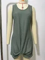 Detailed view of the hollow-out knit texture and twist hem on a green beach dress. - Sage Green