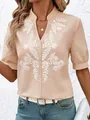 Detail of women's beige cotton shirt with white floral embroidery and V-neckline. - S / Tops / Apricot