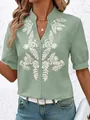 Detail view of white floral embroidery on a sage green cotton short-sleeved casual shirt. - S / Tops / Green