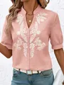 Detailed shot of white floral embroidery on a pink V-neck short-sleeved cotton shirt - S / Tops / Pink