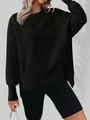Détail d'un sweat-shirt noir oversize avec fente latérale et un col rond classique - S / Hauts / Noir