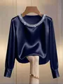 Close-up of navy blue satin blouse with pearl round neck, showing fabric texture and drape - Dark Blue