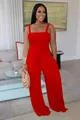 Front view of a solid red smocked bodice wide-leg jumpsuit with spaghetti straps. - Red