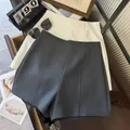 Vue détaillée du short de costume minimaliste gris et blanc à taille haute avec des coutures. - S / Bas / Gris