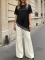 Elegante top in raso nero con pizzo e orlo asimmetrico e pantaloni bianchi. - Taglia S / Top / Nero