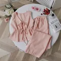 Two-piece striped pajama set featuring a tie-front tank top and loose matching trousers. - Lotus Pink
