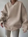 Detail view of a beige oversized V-neck sweatshirt with soft knit texture and ribbed cuffs. - S / Tops / Apricot