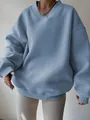 Detail view of a dusty blue oversized sweatshirt with V-neck and ribbed cuffs. - Blue