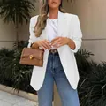 Detail view of stylish white blazer jacket worn with jeans and a brown leather bag - S / Tops / White