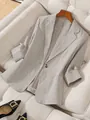Detailed macro view of women's professional light grey linen-texture blazer with notched lapels - S / Tops / Khaki