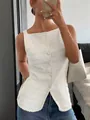 Detailopname van een witte mouwloze top met knopen en een unieke getextureerde kreukstof - S / Tops / Wit