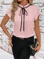 Detailed view of women's pink short sleeve blouse featuring ruffle neck and black bow tie - S / Tops / Pink