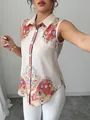 Detail shot of sleeveless button-down blouse with intricate paisley and floral patterns - Almond Blossom