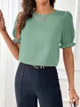 Primer plano de una elegante blusa verde con mangas abullonadas y cuello redondo casual - S / Tops / Verde matcha