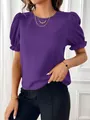 Primo piano di un'elegante camicetta viola con scollo rotondo e dettagli a pieghe sulle spalle. - Viola