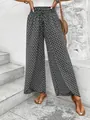 Detailed view of women's high-waisted black and white floral wide-leg pants on stairs - S / Bottoms / Black