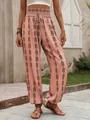 Detail view of peach bohemian printed harem pants with ethnic black geometric patterns - S / Bottoms / Orange