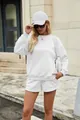 Full-length outdoor detail view of model wearing a minimalist white two-piece lounge set - White