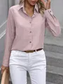 Detail view of a pink long-sleeved button-down shirt paired with white trousers. - S / Pink