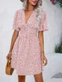 Detail view of pink floral V-neck dress with high waist and puff sleeves. - Pink
