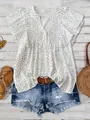 Detailed view of white polka dot V-neck blouse styled with denim shorts and belt. - S / Tops / White
