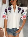 Gros plan blouse blanche col en V avec broderies florales et détails de col à volants. - S / Hauts / Floral Rose-Mauve