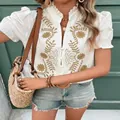 Détail d'une blouse en coton blanc avec broderies florales et manches bouffantes été - S / Hauts / Abricot
