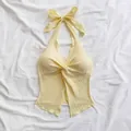 Close-up view of a yellow halter top featuring a twisted front and ribbed fabric - XS / Tops / Light Yellow