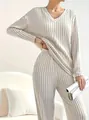 Close-up of elegant cream V-neck ribbed knit two-piece set with straight pants. - S / Top And Bottom / Off White