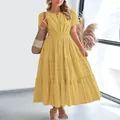 Detail of a yellow tiered V-neck maxi dress with short puff sleeves on a model. - Yellow