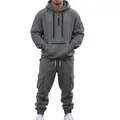 Full view of a male model wearing a grey hooded tracksuit with functional cargo pockets. - M / Top And Bottom / Dark Gray
