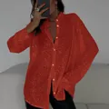 Macro view of red sequined shirt texture with long sleeves and classic lapel collar - Red