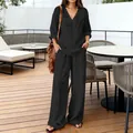Casual black V-neck top and wide-leg pants set shown in a stylish outdoor patio setting. - Black