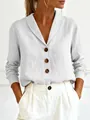 Close-up of white cotton linen blouse featuring a shawl collar and large brown buttons - S / Tops / White
