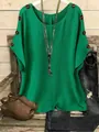 Detalle de una blusa verde holgada con botones de madera decorativos y collares de plata - S / Tops / Verde
