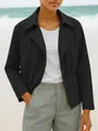 Detalle de una chaqueta tipo blazer corta negra para mujer en un entorno exterior elegante - S / Tops / Negro