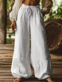 Close-up of white textured wide-leg trousers with elastic drawstring waist and pockets - S / Bottoms / White