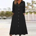 Close-up detail of a black textured long-sleeve shirt dress with white buttons and pockets - S / Tops / Black