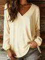 Elegant detail view of a loose cream V-neck blouse with lantern sleeves on a model. - S / Tops / Light Yellow
