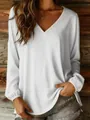 Detail of white women's loose long-sleeve V-neck pullover blouse against wood wall - S / Tops / White