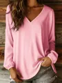 Detailed view of women's casual pink V-neck long sleeve blouse with rustic wooden wall backdrop - Pink