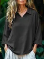 Detail showing the V-neck collar and fabric texture of the black loose shirt. - Black