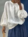Detalle de una blusa blanca de lino con elegantes mangas farol y cuello redondo clásico. - S / Tops / Blanco