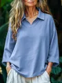 Detail van het losvallende blauwe shirt met lange mouwen en revers in een natuurlijke setting - S / Tops / Hemelsblauw