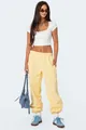 Volledige lichaamsweergave van een model in gele joggingbroek met witte crop top en sneakers. - S / Bottoms / Lichtgeel