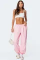 Vrouwelijk model in lichtroze joggingbroek met hoge taille en witte crop-top in studio - S / Bottoms / Roze